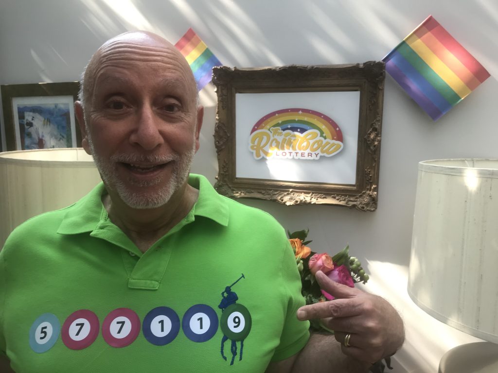 The winning numbers are dramatically stuck on Tom Gattos' chest by co-founder, David Murray.